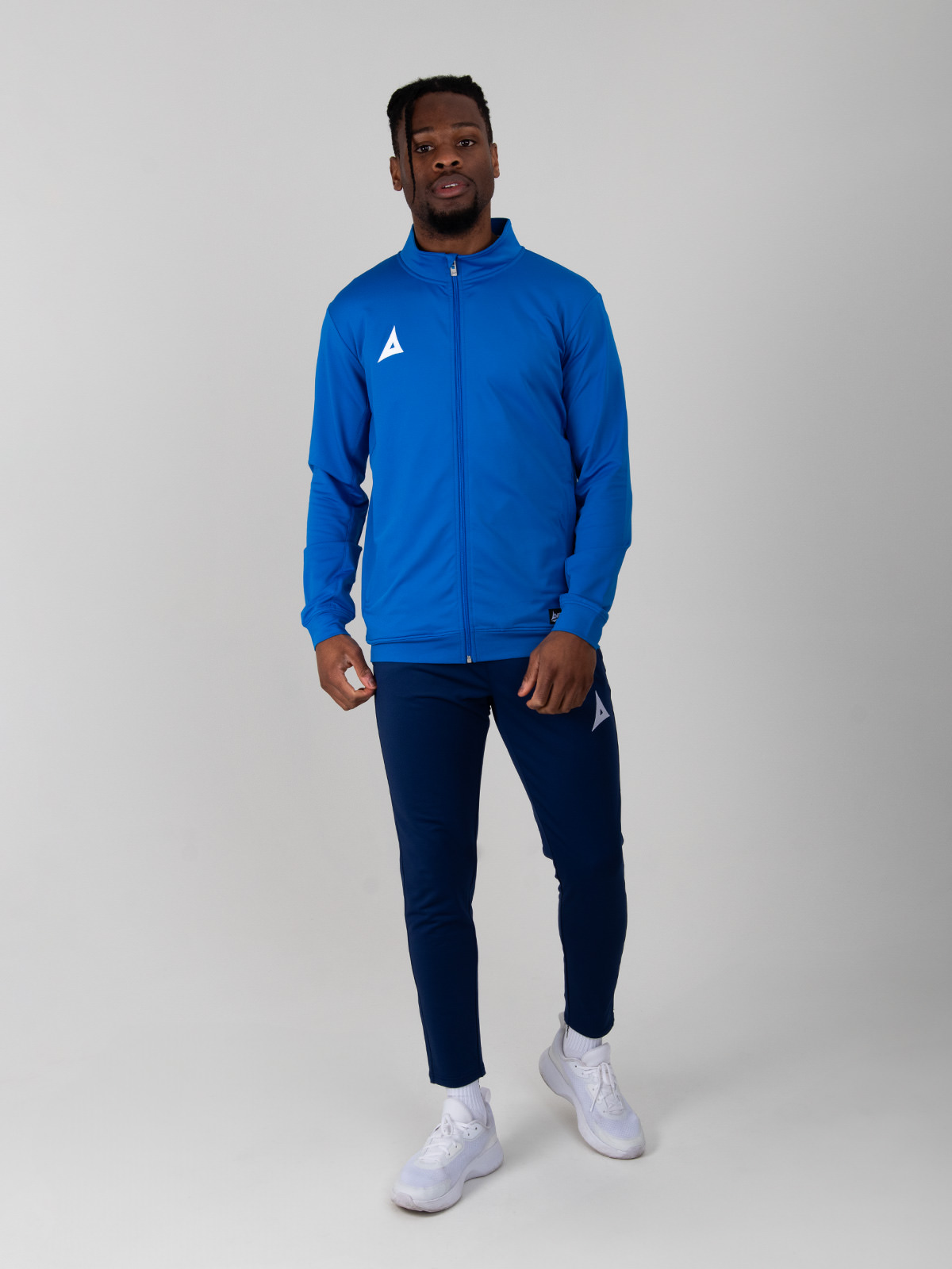 model wearing a royal blue tracksuit jacket with navy tracksuit bottoms.