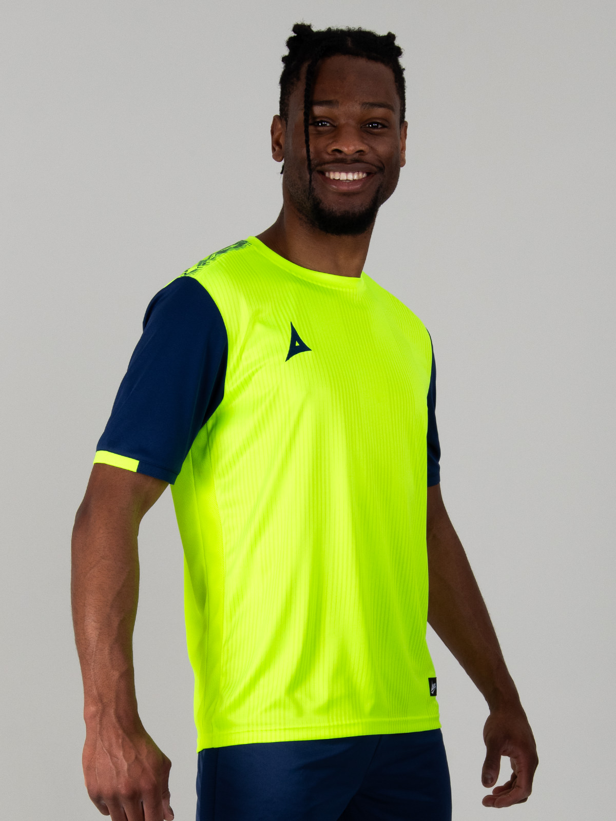 model wearing a bright yellow football top with navy sleeves