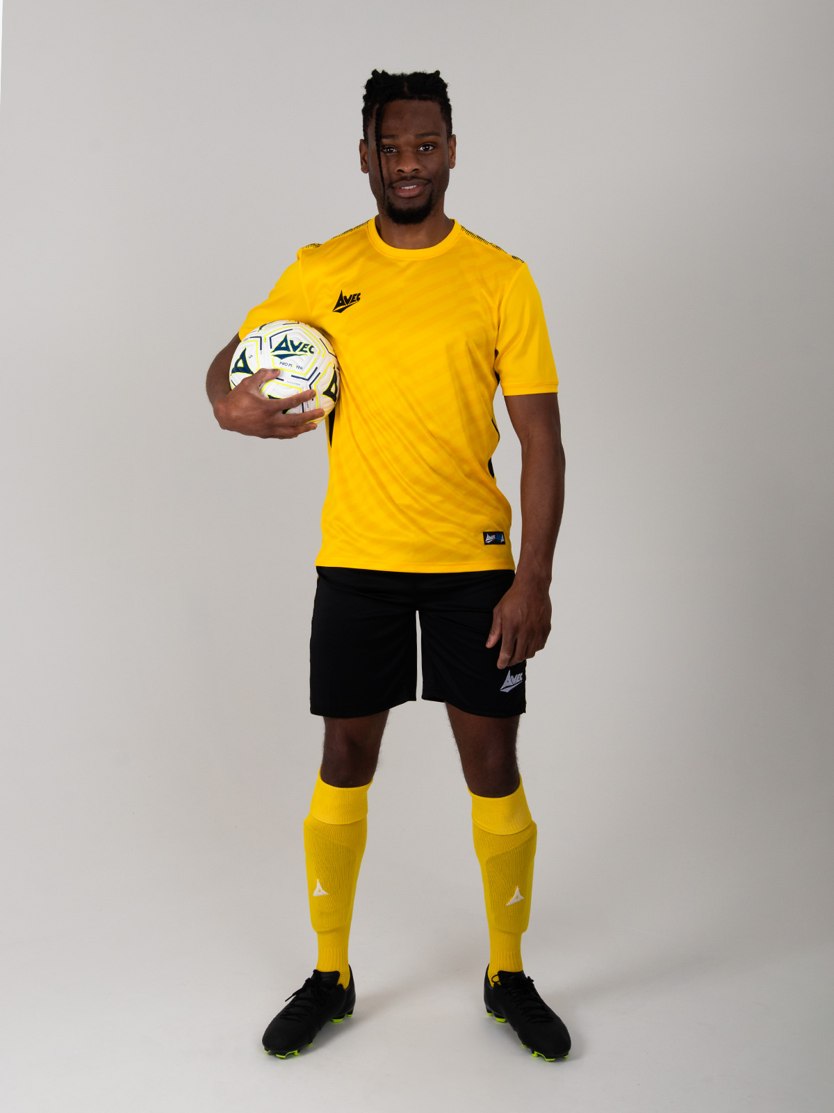 a man is wearing a yellow football kit, but has black shorts in this combination.