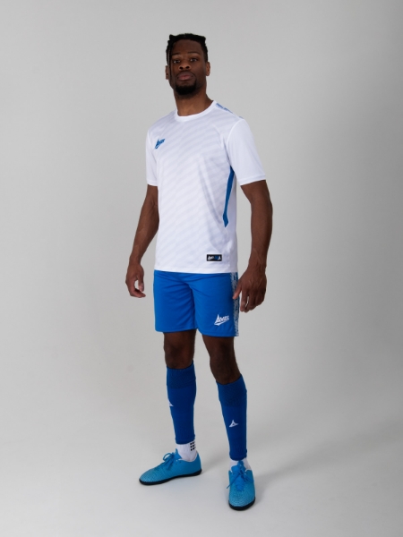 A player is wearing a white football shirt which has royal blue mesh panels, royal blue shorts and socks