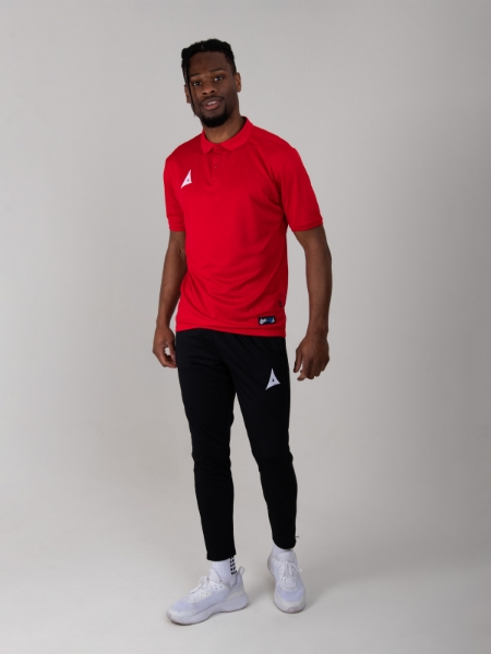 A red polo shirt is worn with a pair of black joggers