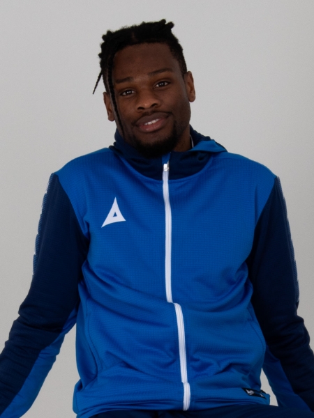 A man looking relaxed in a blue hoody featuring a white zip