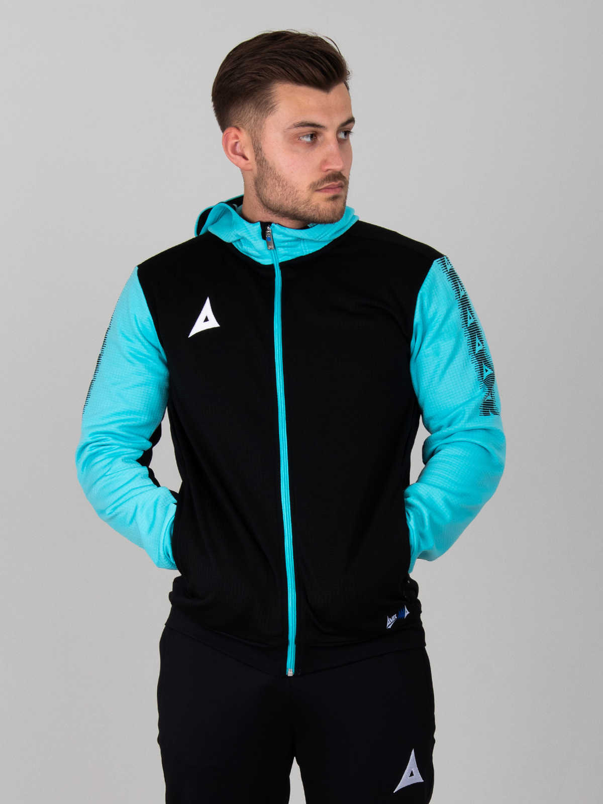 a man is wearing a black hoodie with a full zip. the item has pale blue sleeves and zip