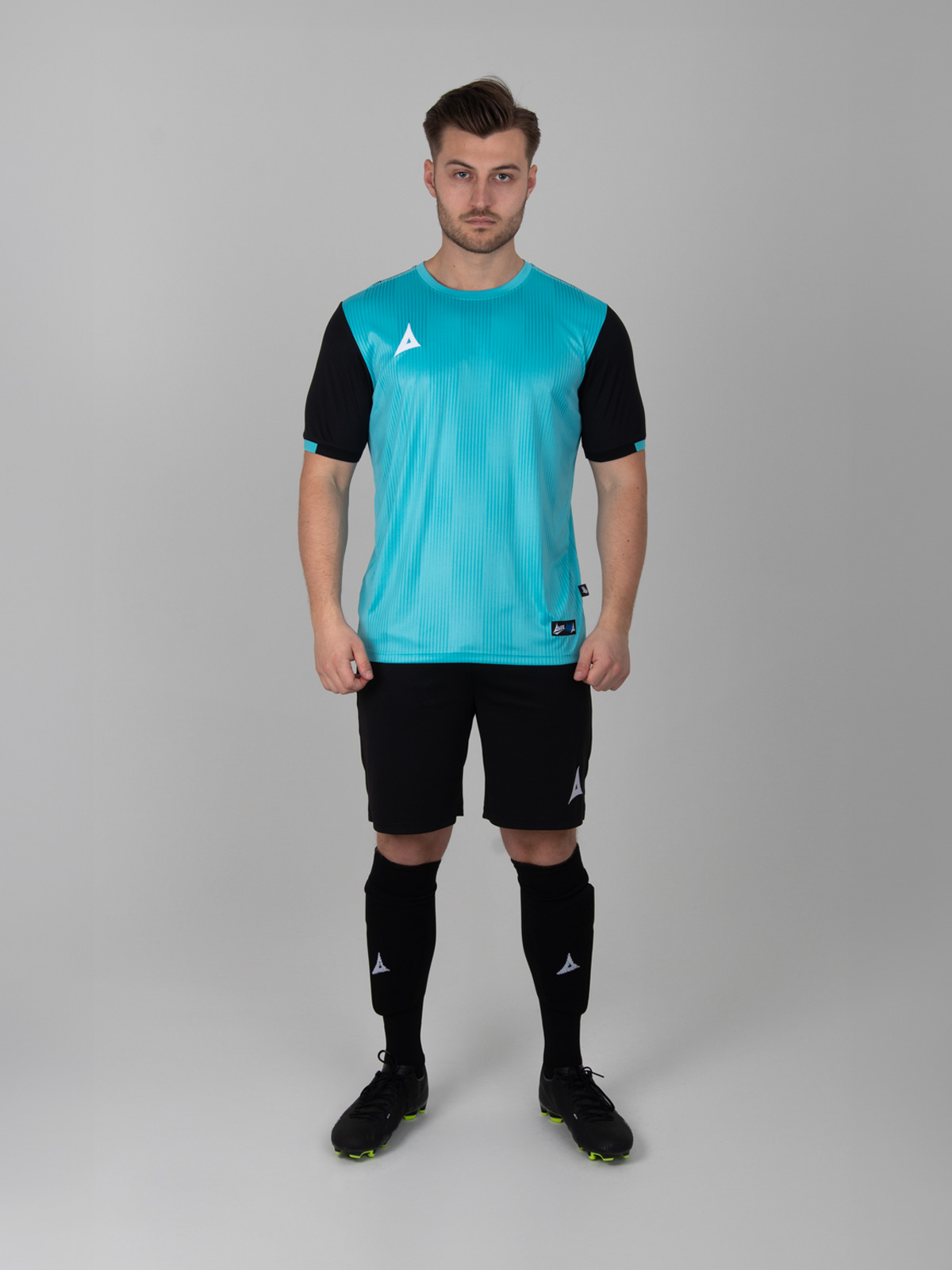 a male model wearing a light blue football shirt with a graphic print and black sleeves