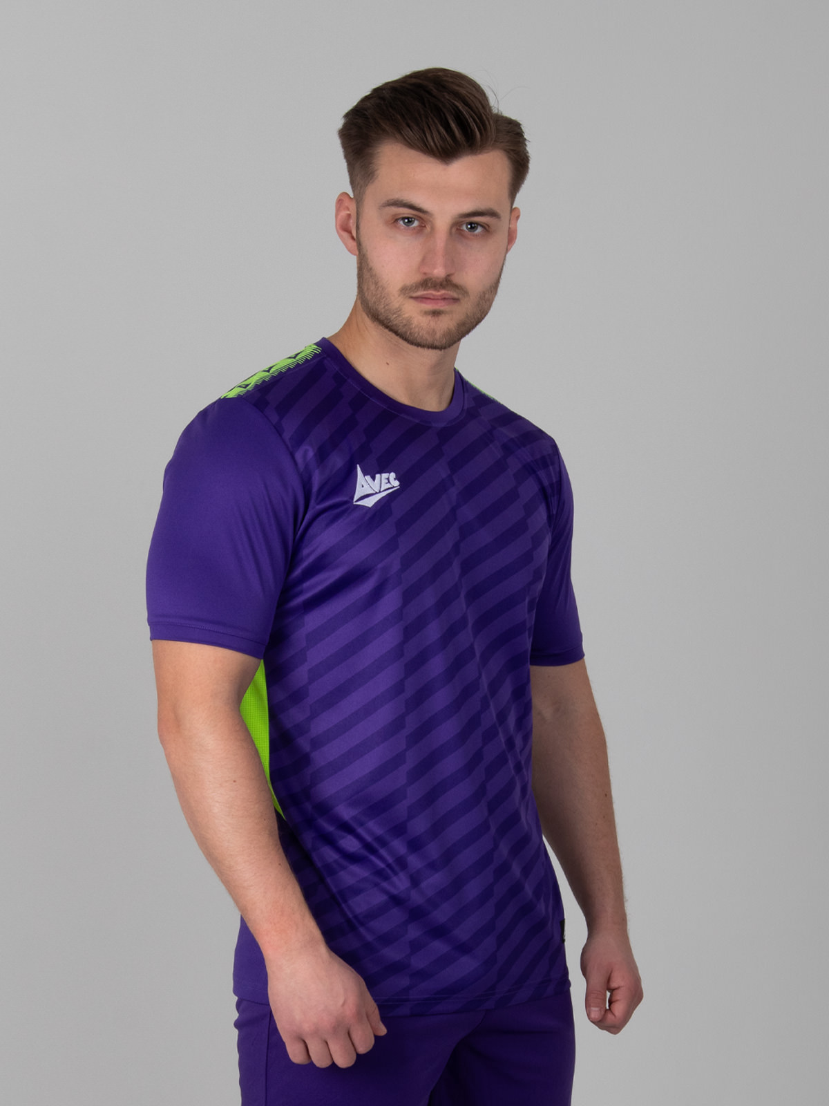 a man wearing a purple football shirt with two-tone graphic print and a volt side panel