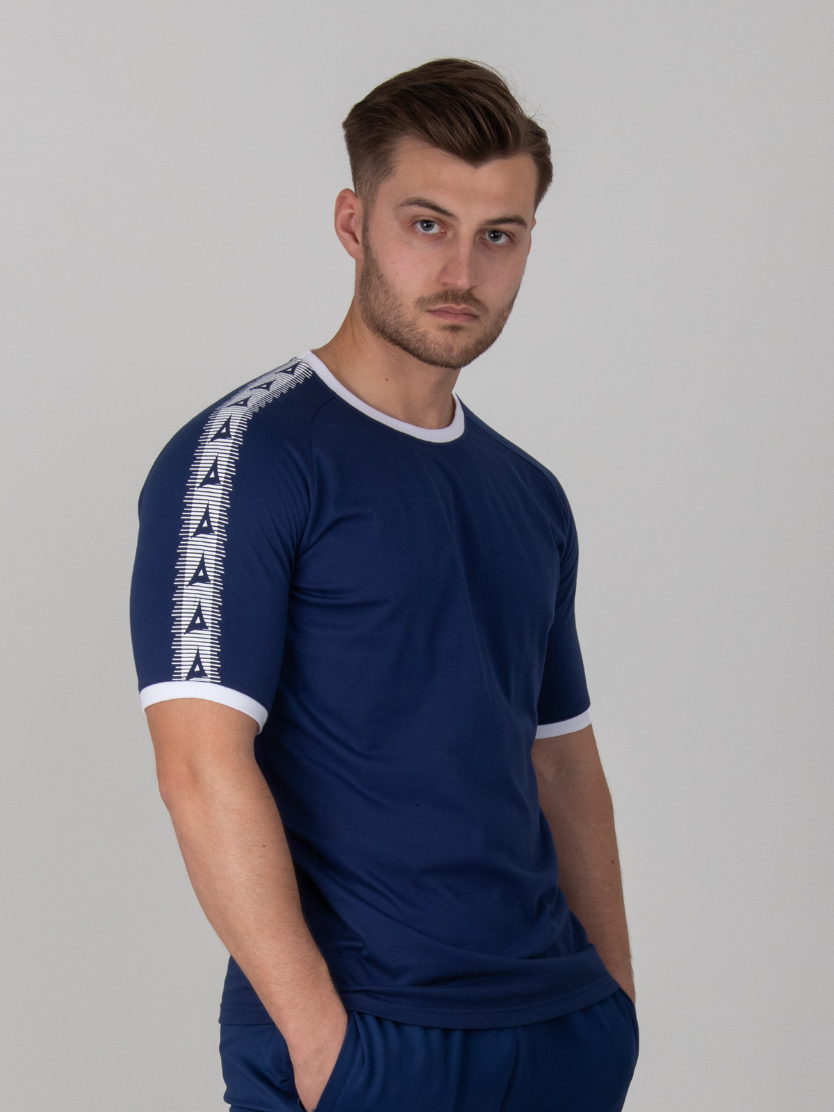 a man is wearing a navy t-shirt with white trim on the collar and sleeves