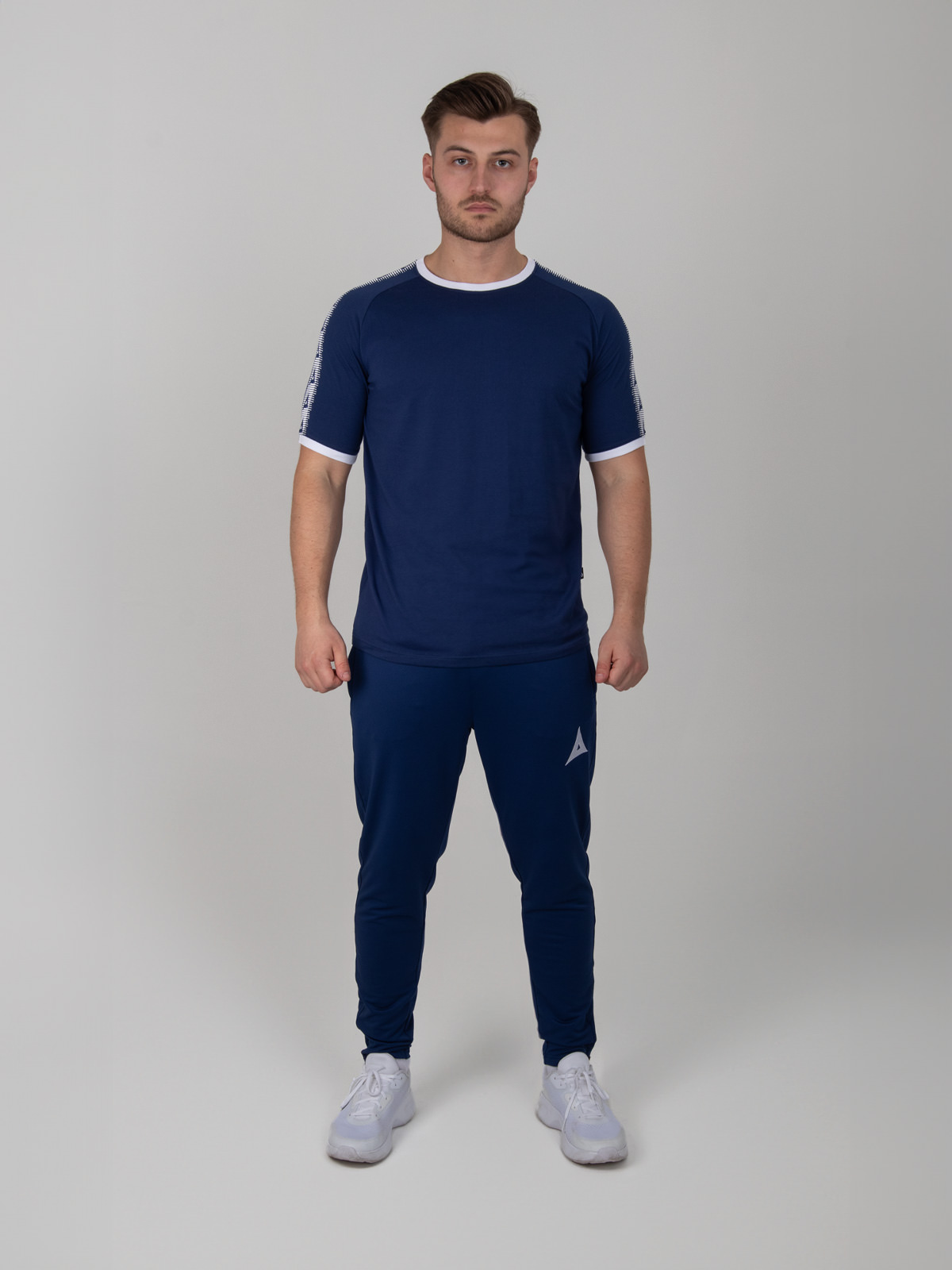 a navy cotton t-shirt with white trim is matched with navy jogging bottoms