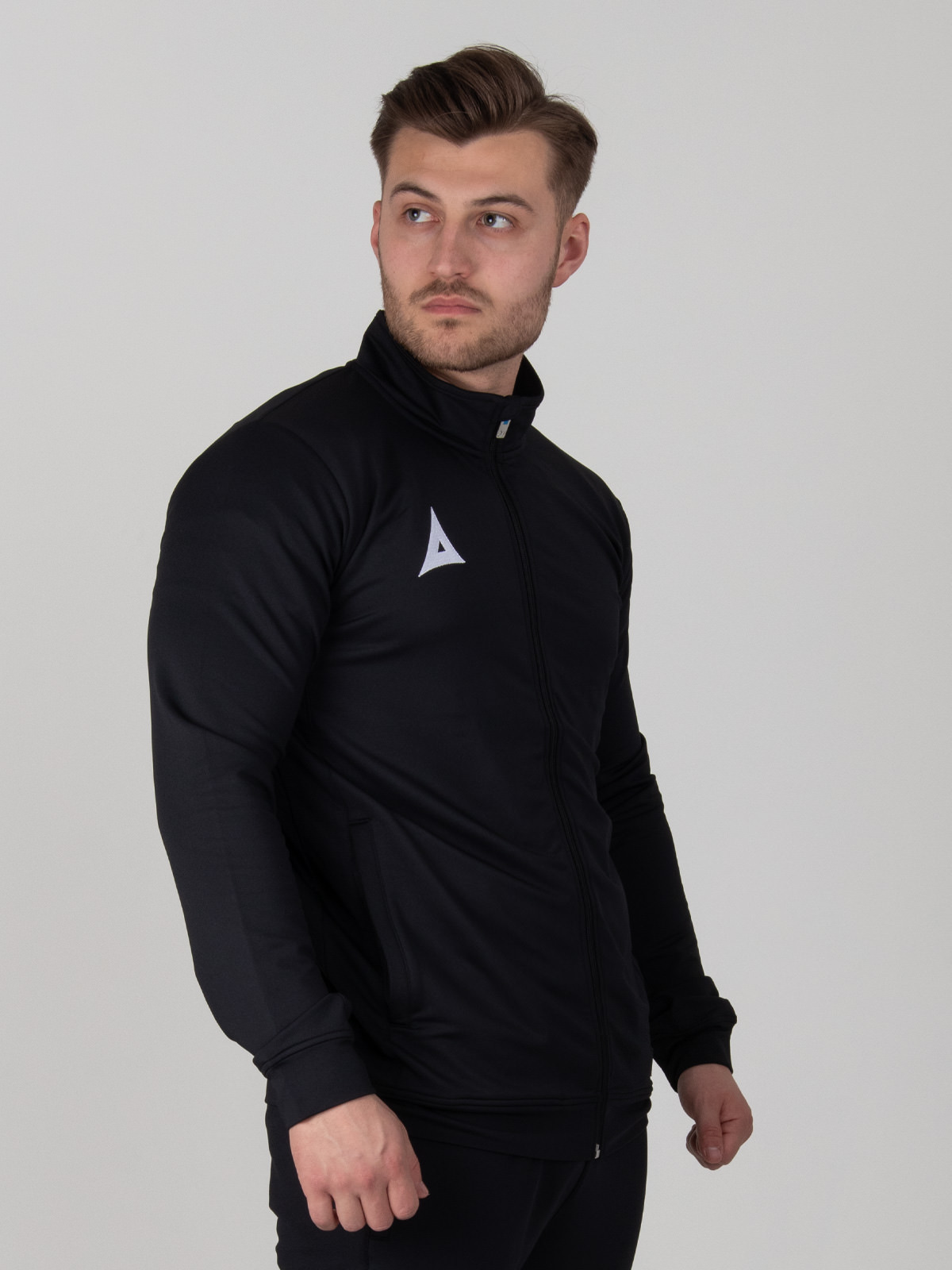 a polyester black tracksuit jacket with a full zip is worn by a man.