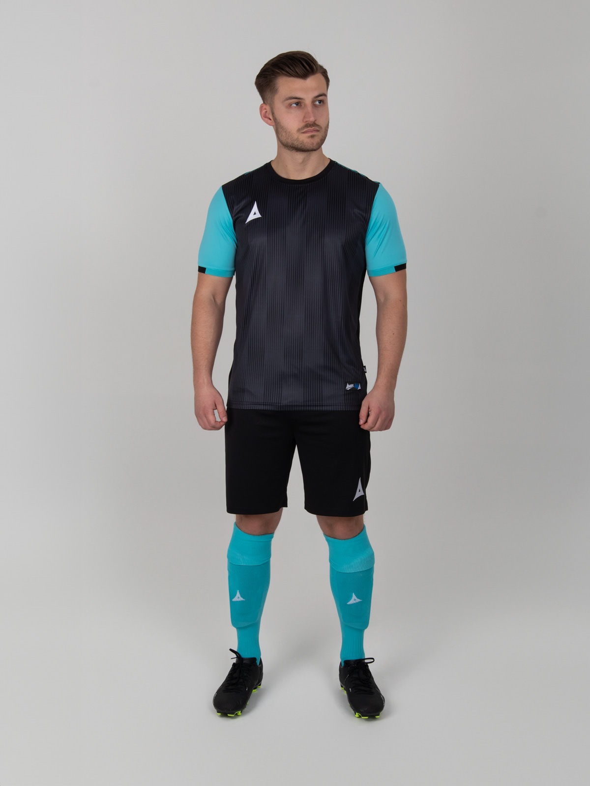 a man is wearing a black football shirt with pale blue sleeves, black shorts and light blue socks. 
