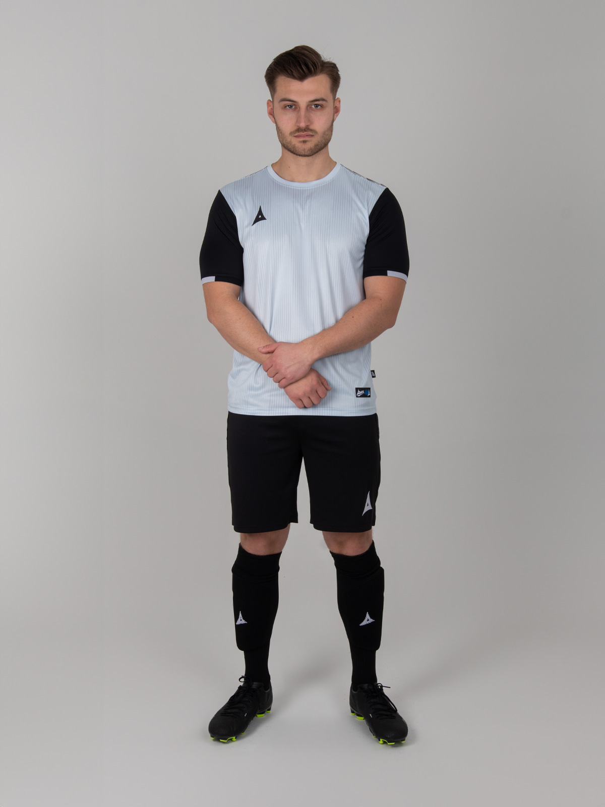 a grey football shirt is worn with black shorts and socks to match the sleeves of the top.