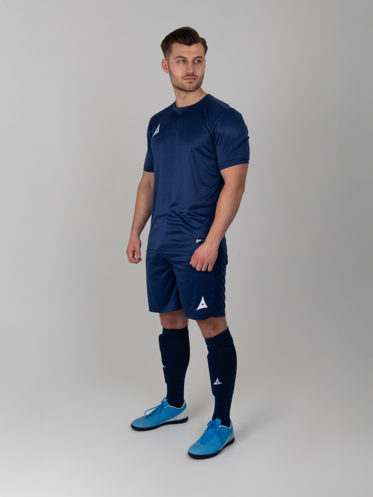 a man wearing an all navy blue football kit