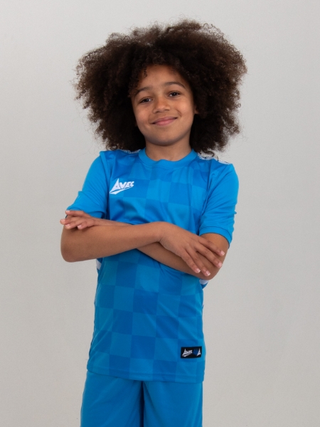 A young boy is wearing a sky blue football shirt with a tonal chequered board design