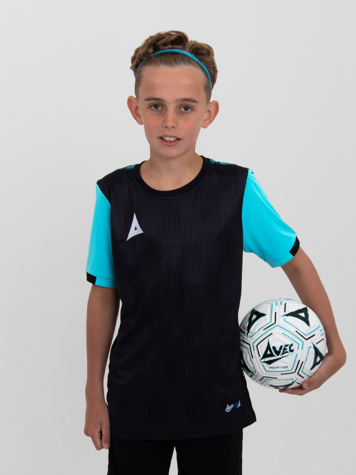 a boy is holding a size 4 football and is wearing a black football shirt with light blue sleeves