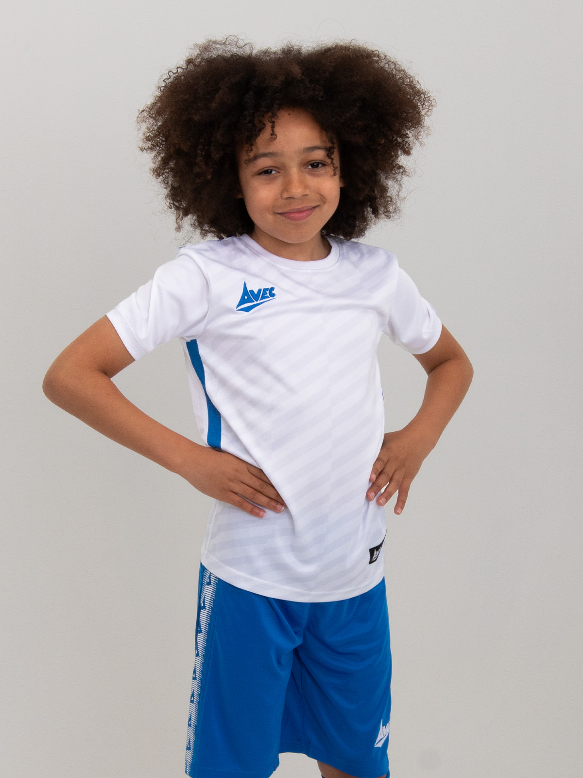 a children's white football shirt is modelled by a boy.