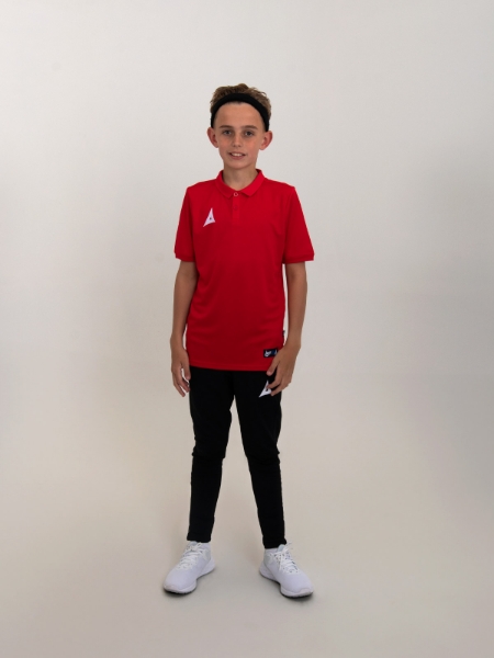 A junior polo shirt in red is worn with black tracksuit bottoms