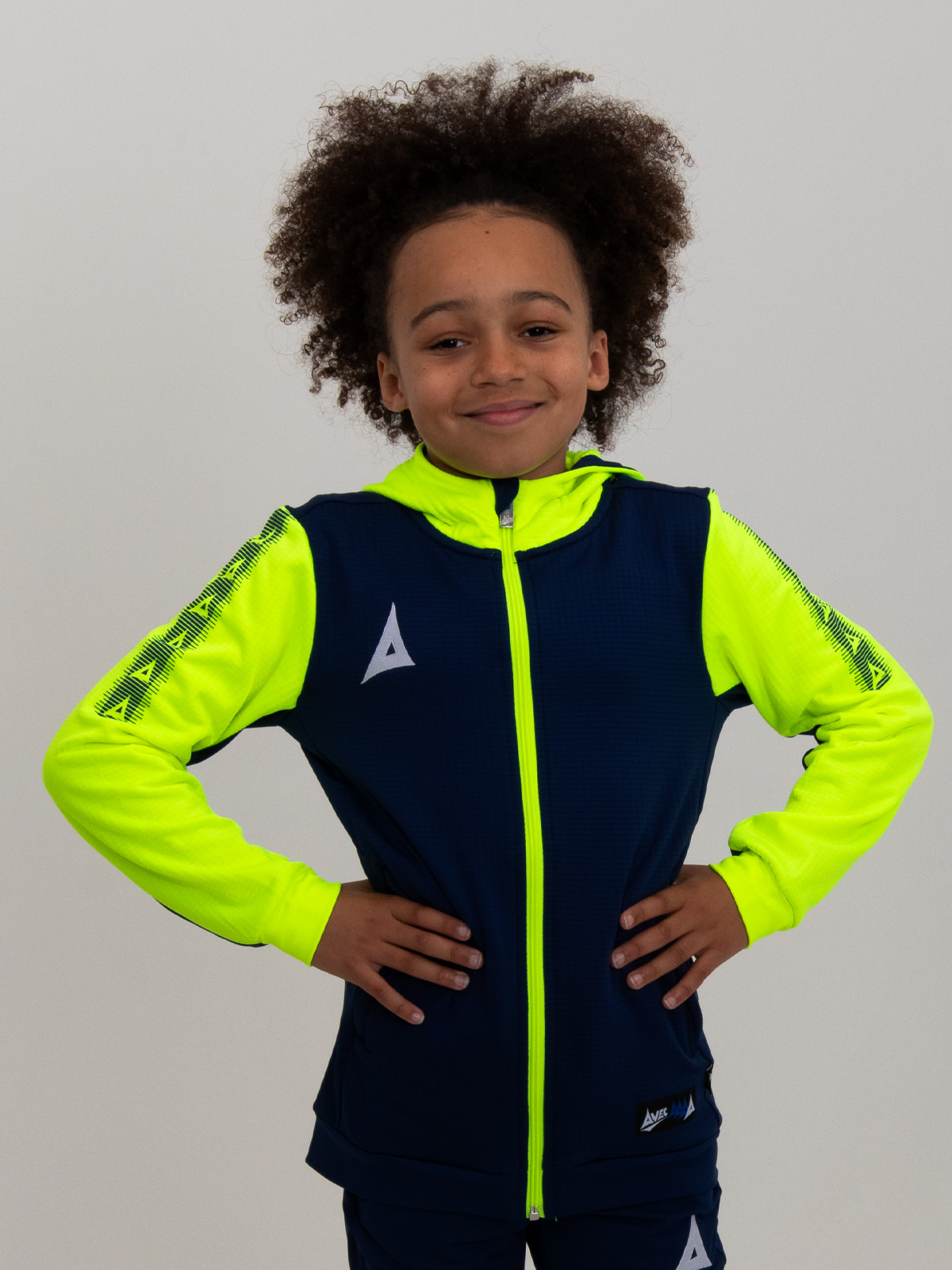 a young boy in a vibrant neon yellow and blue hoody, radiating energy and style.