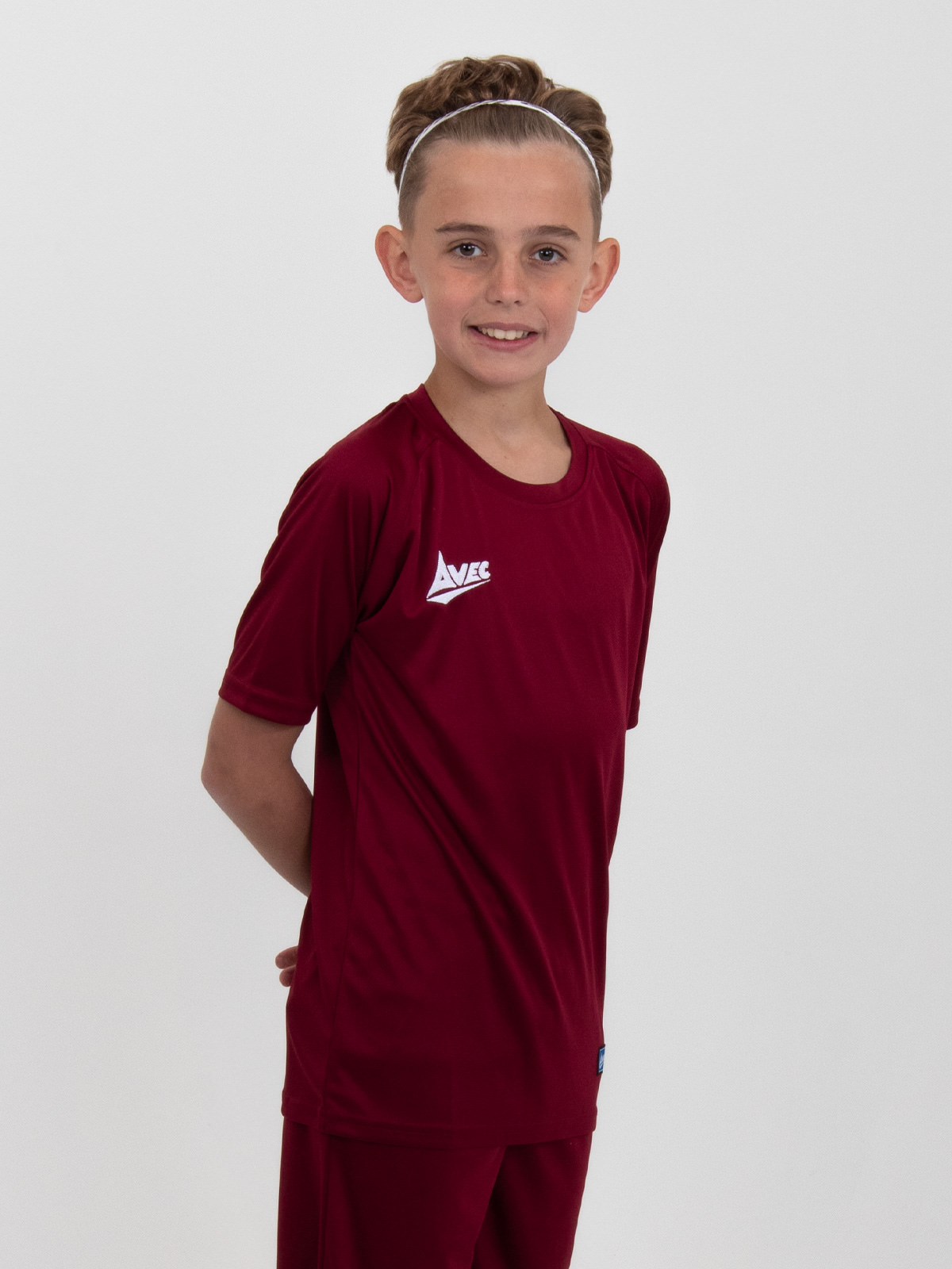 a children's claret football shirt is being worn by a young boy.