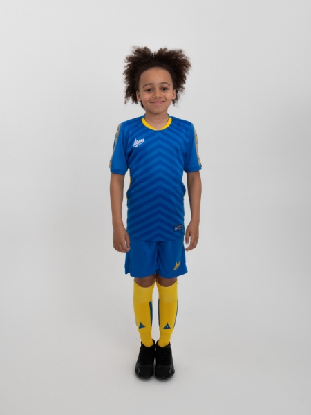 An alternative kit combination of Royal Blue Shirt, Blue Shorts and yellow socks is worn by a junior footballer.