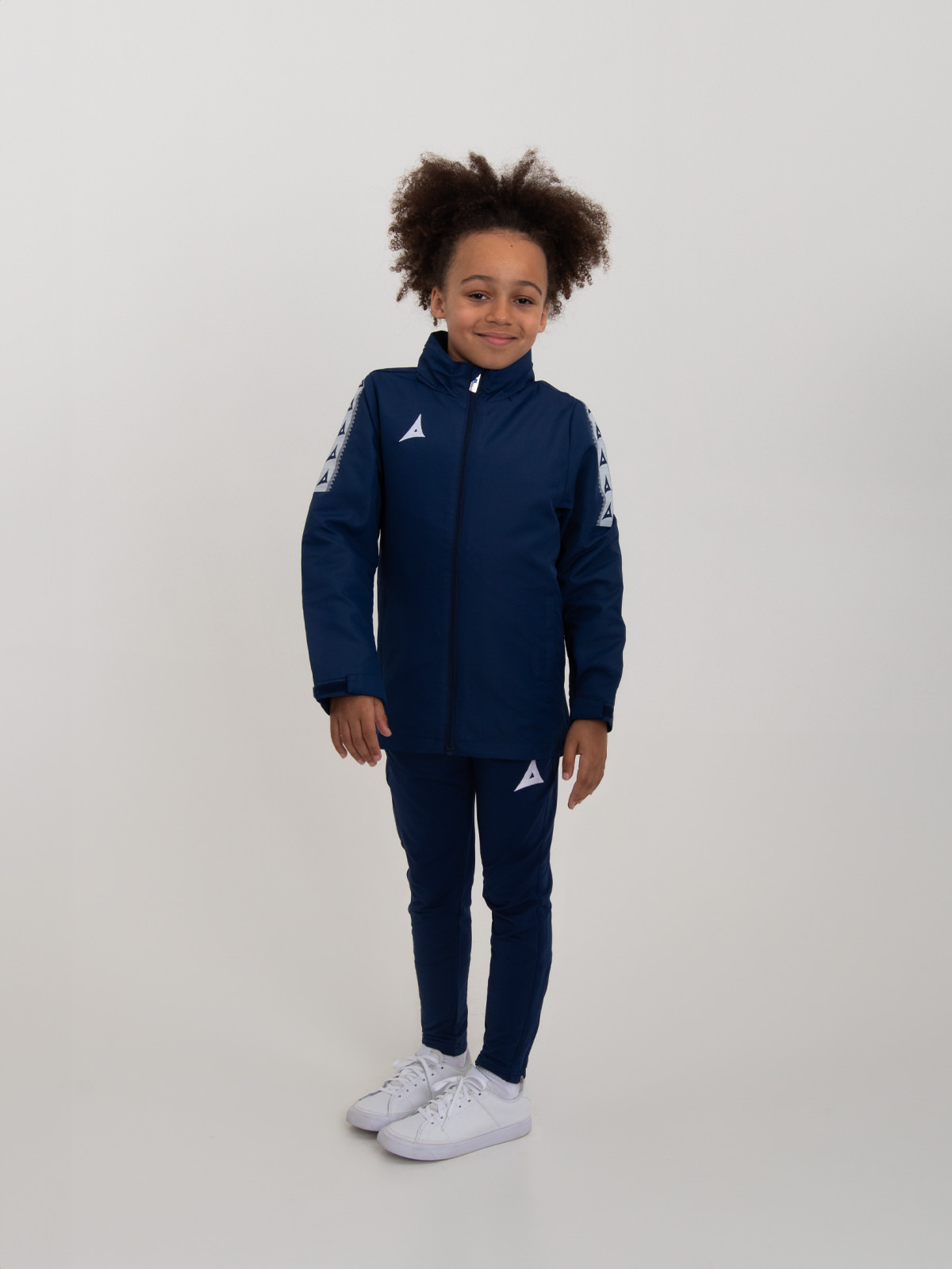a junior rain jacket in navy blue is being worn by a young child