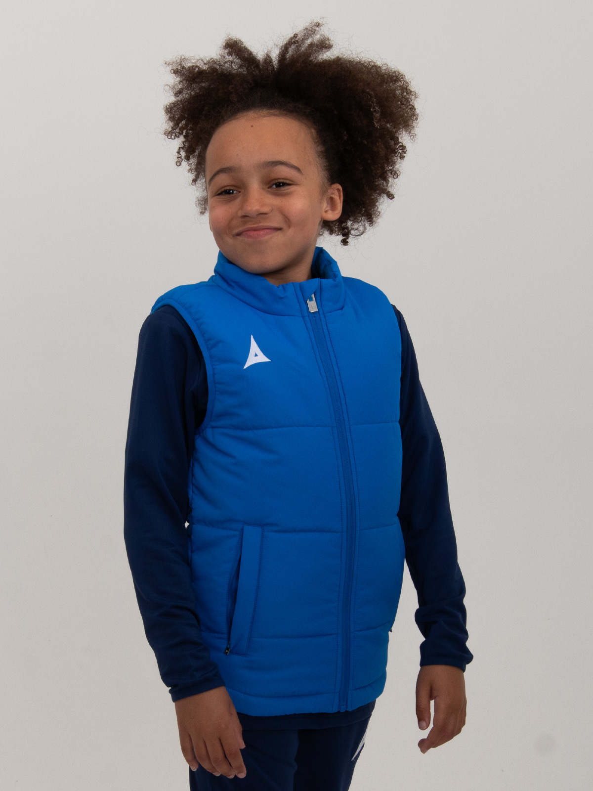 a young boy is wearing a royal blue padded gilet