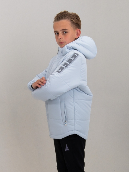 A young boy is turned to the side wearing a light grey padded jacket that looks very warm.