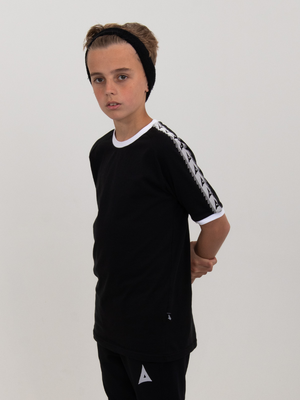a kids plain black cotton t-shirt is bring worn by a child