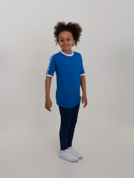 A child is modelling a royal blue t-shirt combined with navy tracksuit bottoms