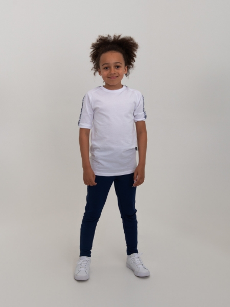 A boy is posing in our white classic shirt, with navy sleeve details.