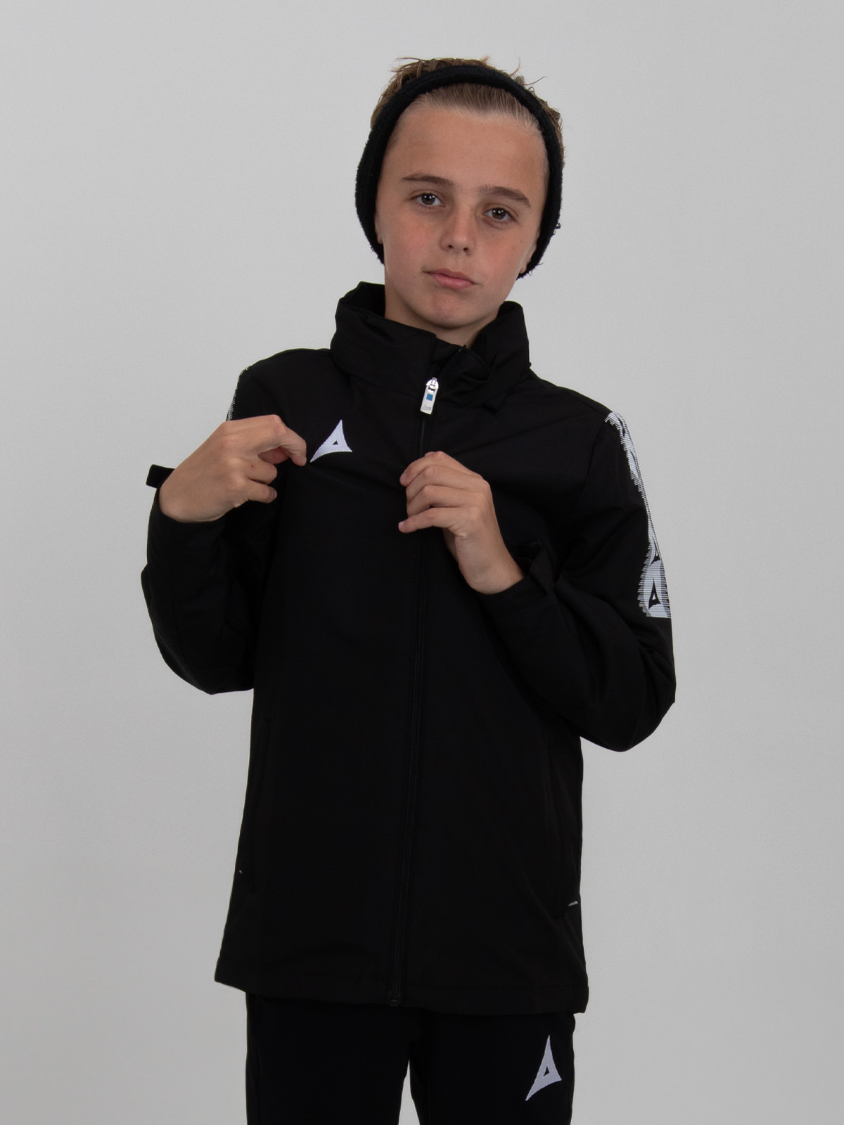 this rain repellent black rain jacket for children is modelled by a young child.