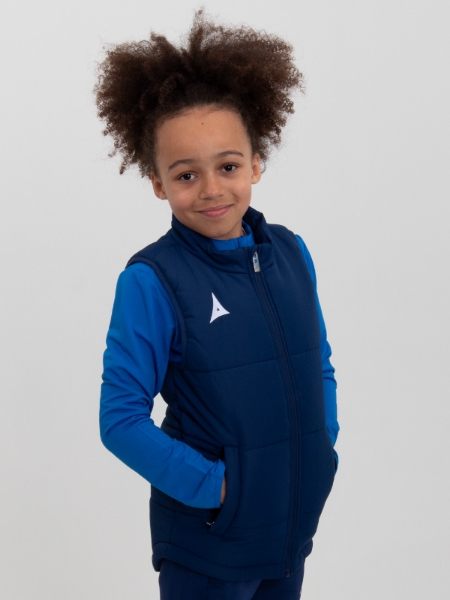 A boy is wearing a childrens padded gilet in navy