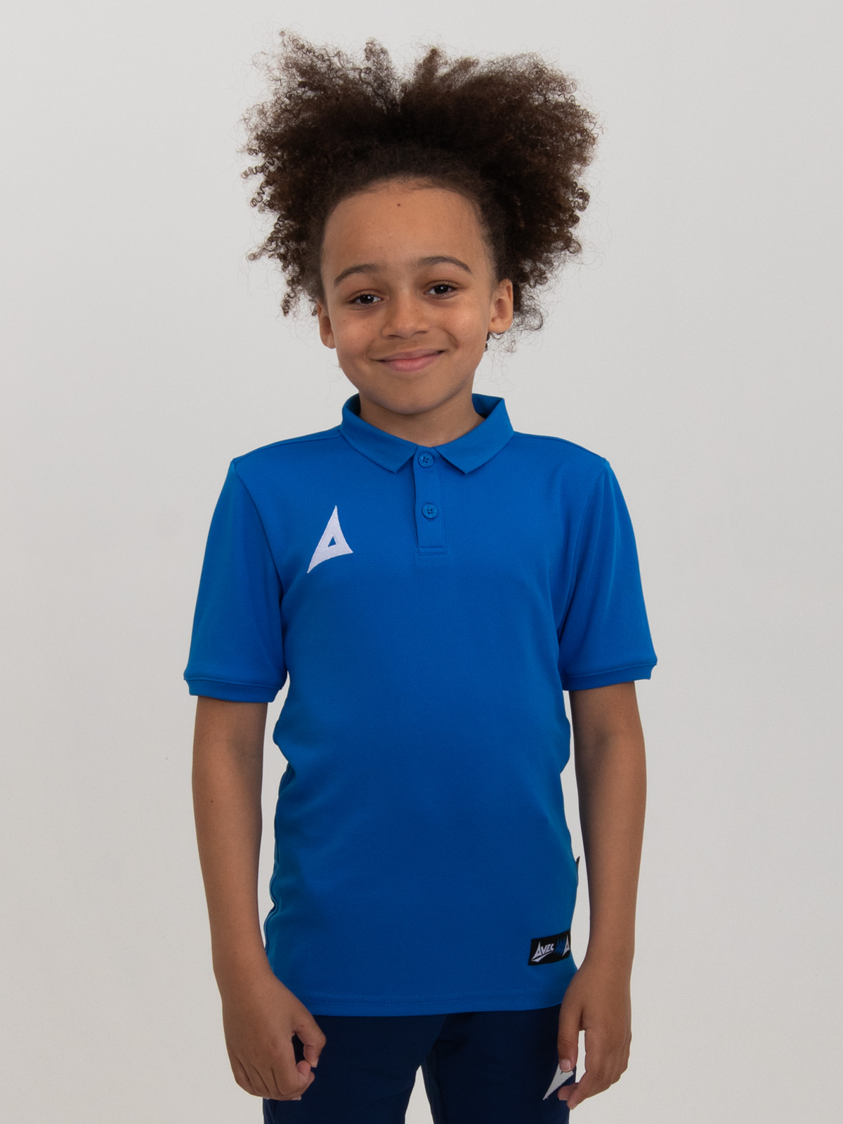 a child is smiling while wearing a plain royal blue sports polo