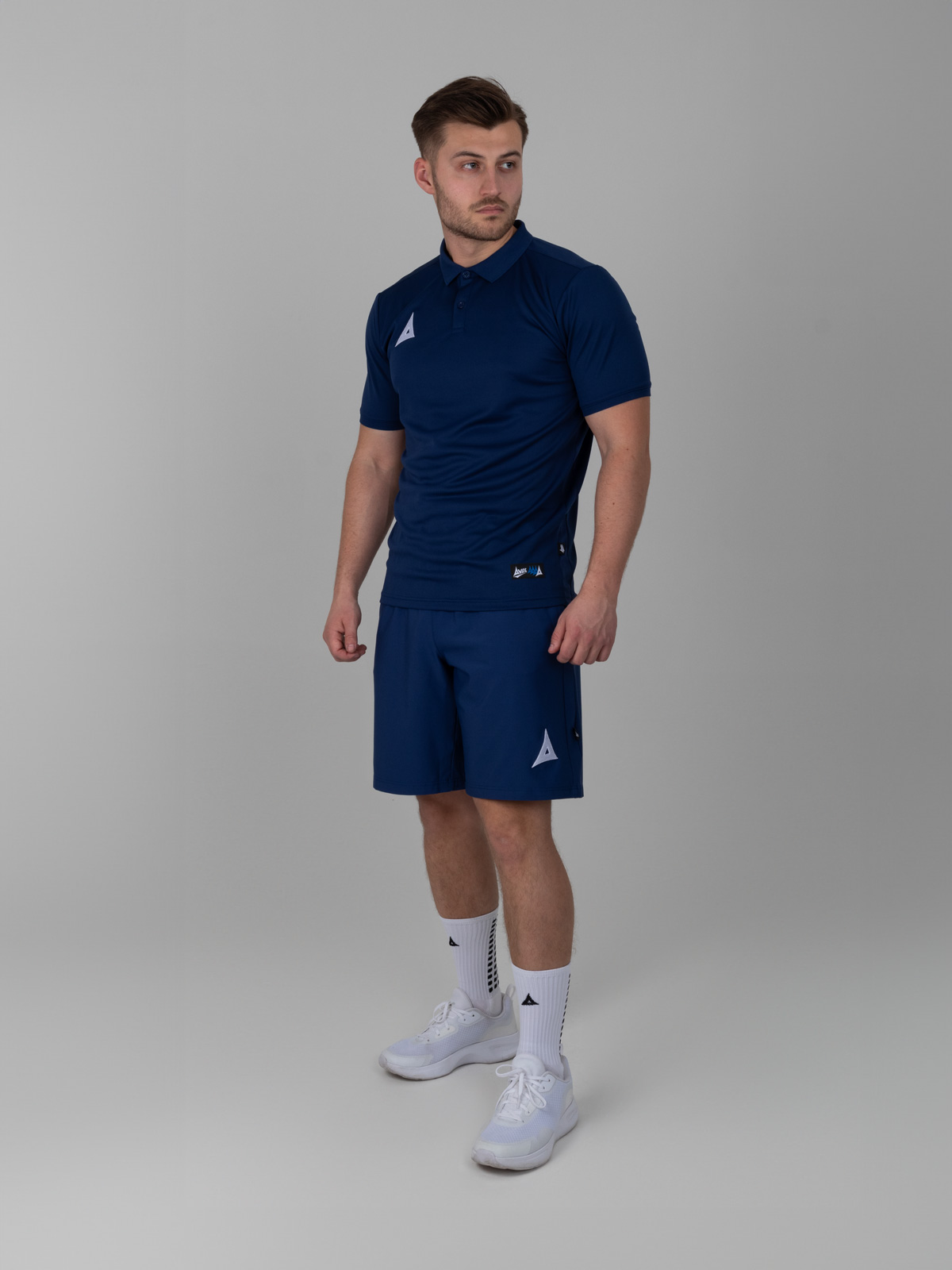 an all blue outfit with a navy blue longer short is worn with a navy polo for a classic sports look