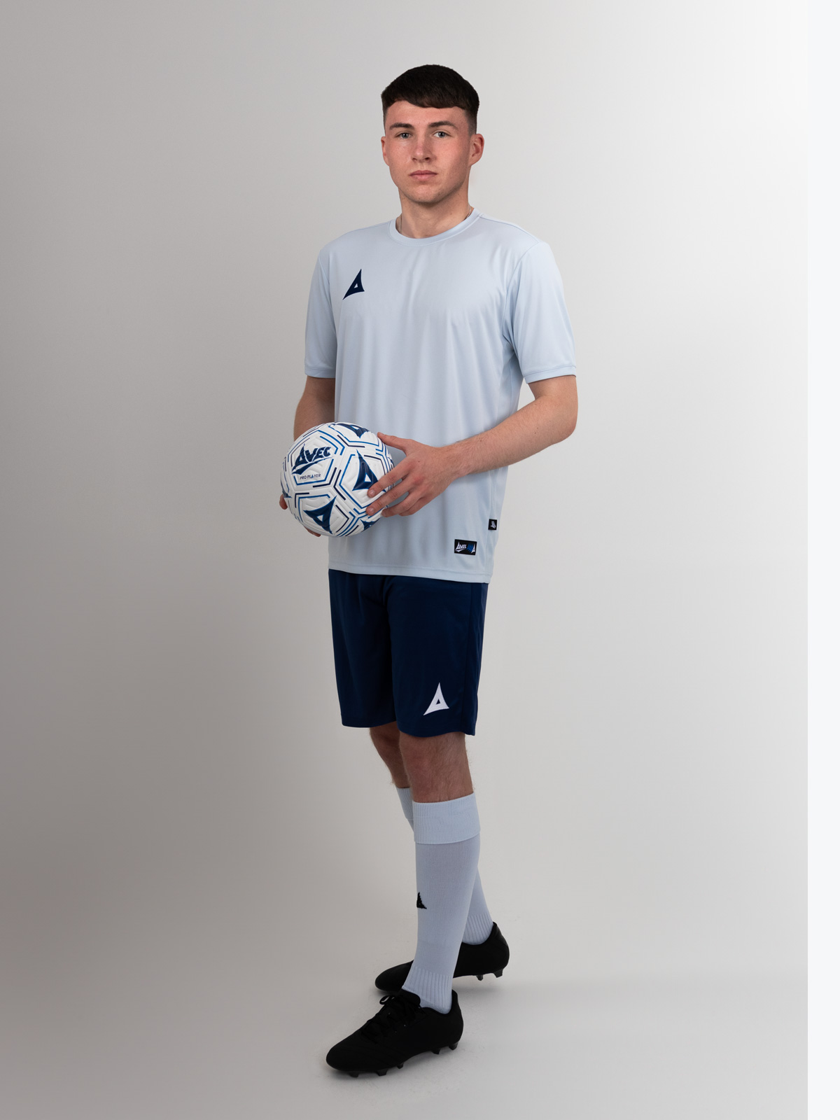 this man is wearing a grey football shirt with navy football shirts and grey socks for a classic football kit look. 