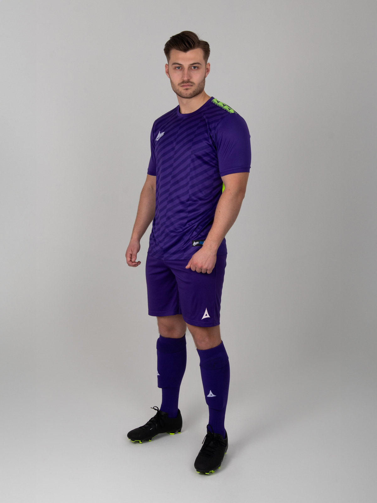 a man wearing a full purple football kit of purple shirt, purple shirts and purple socks.