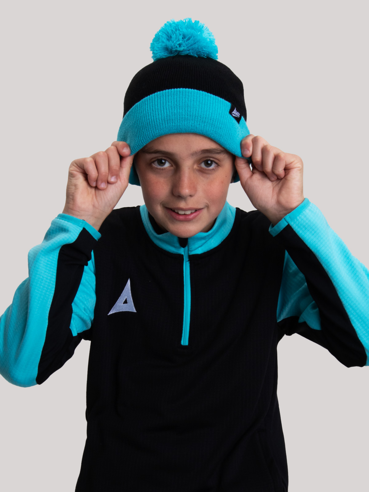 a young child wearing a black and blue bobble hat.