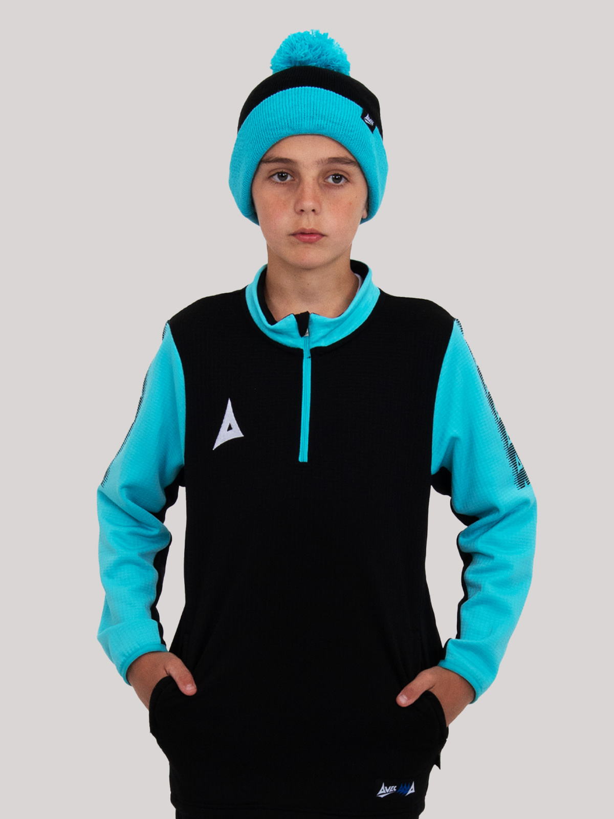 a junior is wearing a black and light blue bobble hat, with a matching jumper. 