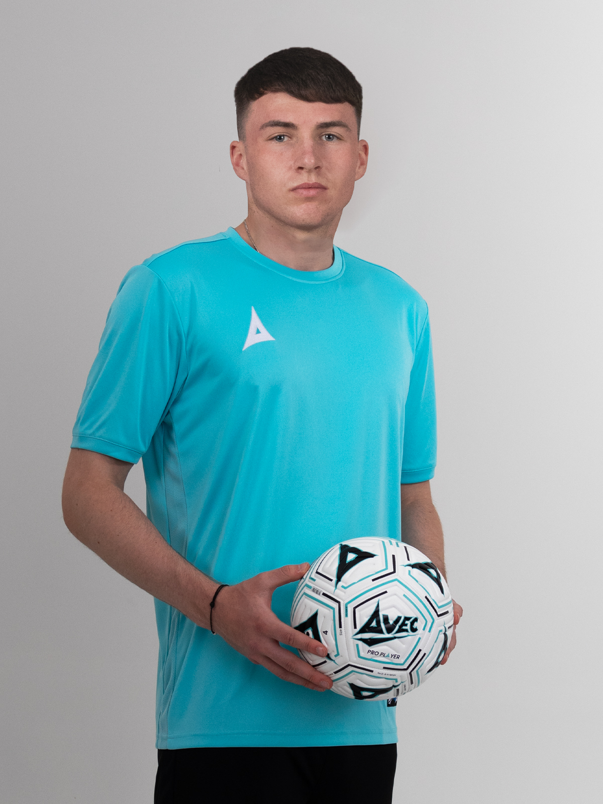 a man wearing a pale blue football shirt, holding a football