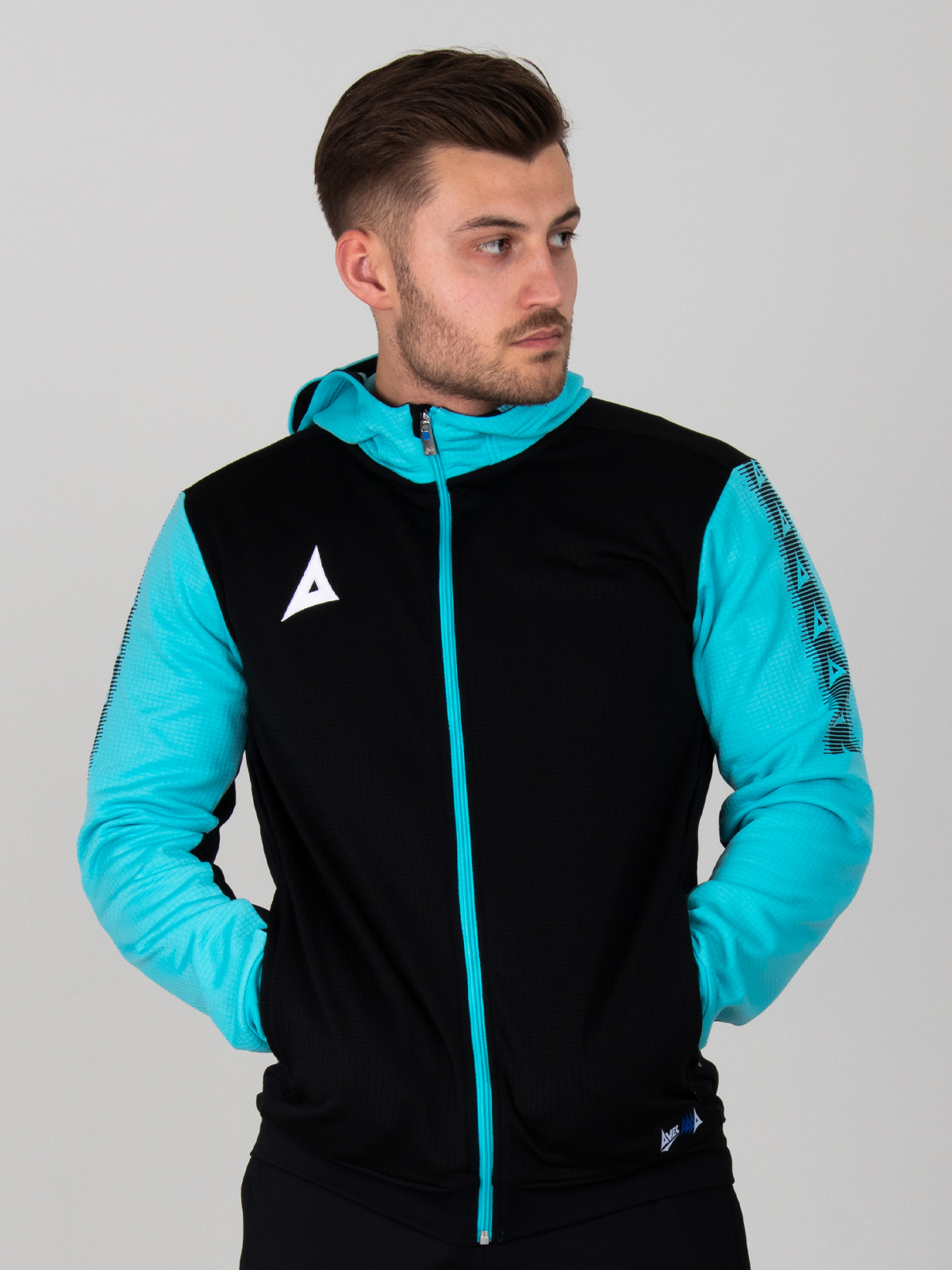 a man is wearing a black hoodie with a full zip. the item has pale blue sleeves and zip