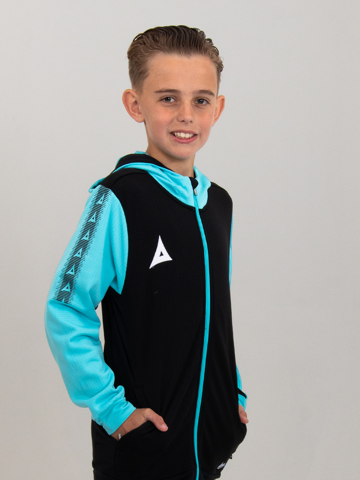 a kids black hoody with pale blue sleeves and hood is being worn by a child.