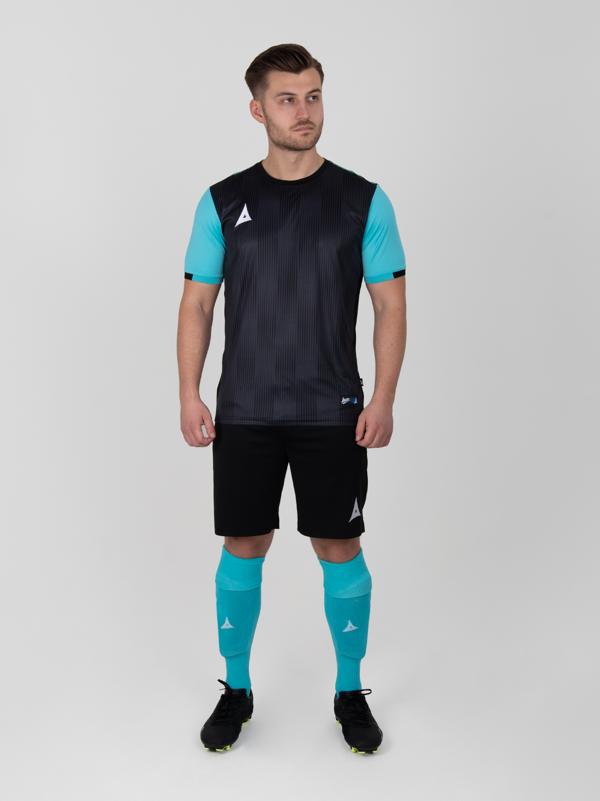 a man is wearing a black football shirt with pale blue sleeves, black shorts and light blue socks.