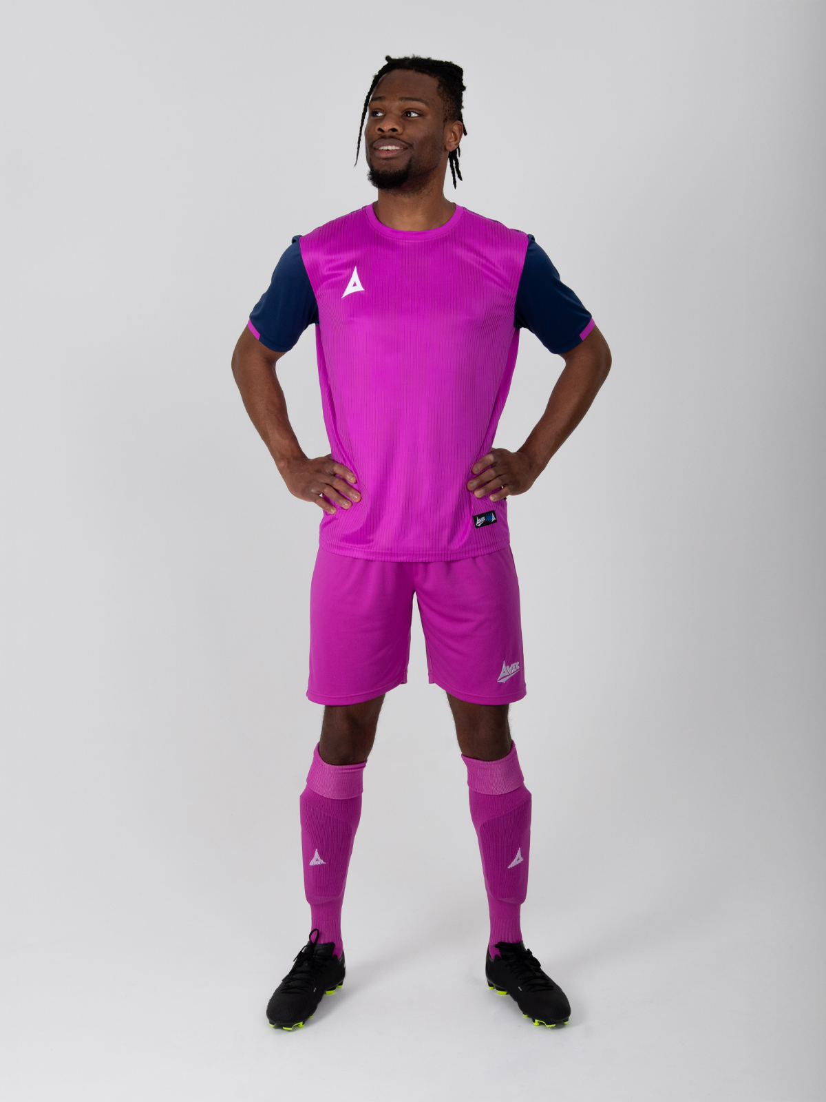 man wearing magenta pink football shorts in a matching kit