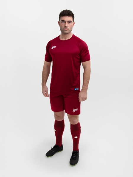 An Adult man is wearing a full plain claret football kit