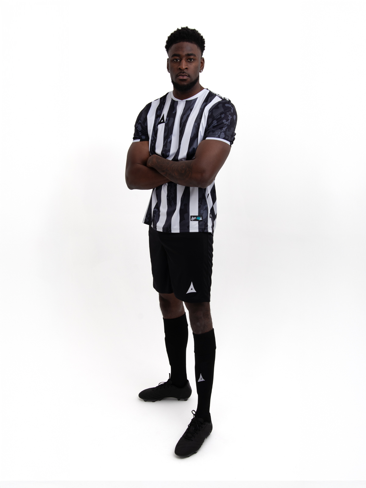 a man in a black and white stripe shirt, black shorts and socks. 