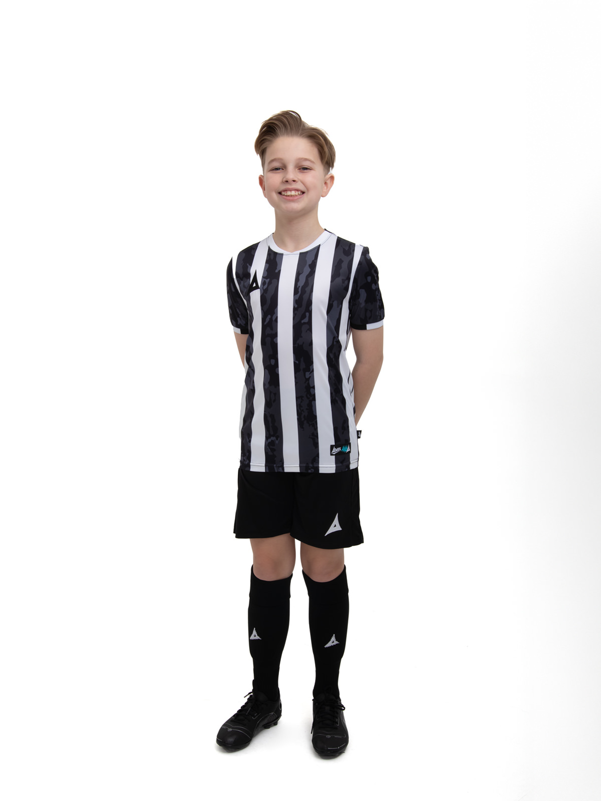 a young child in a black and white stripe shirt, black shorts and socks. 