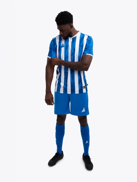 A man is wearing a royal Blue and White stripe football shirt, with a royal blue pair of shorts and socks