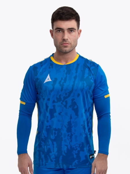 A model standing up wearing a royal blue football shirt with a compression underlay in royal blue and yellow details