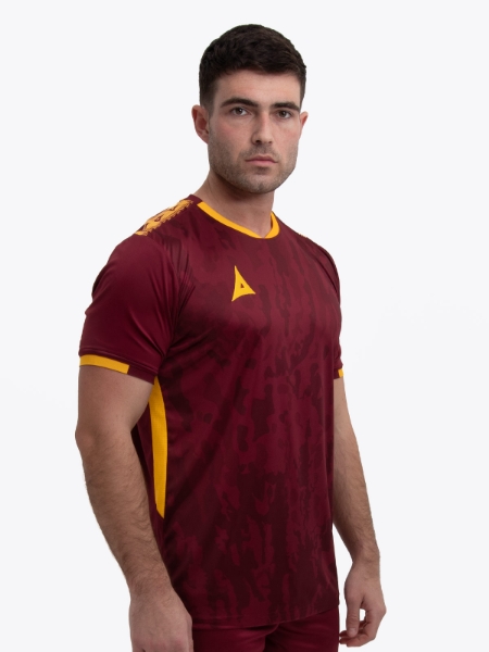 A model wearing a claret / maroon football shirt with amber accents