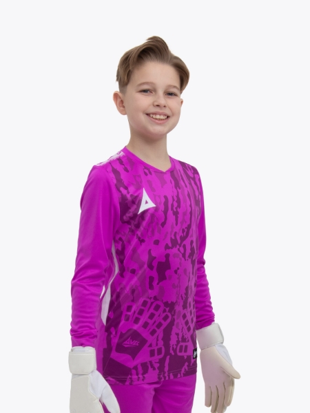 A child standing up wearing a magenta goalkeeper football shirt