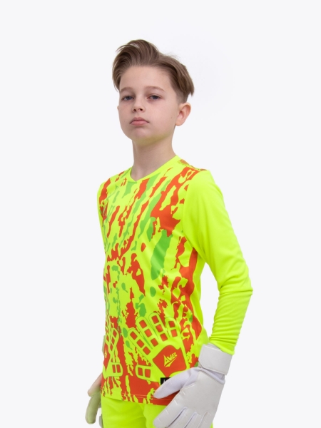 A kid is wearing a neon yellow goalkeeper football shirt with orange panels and detailing