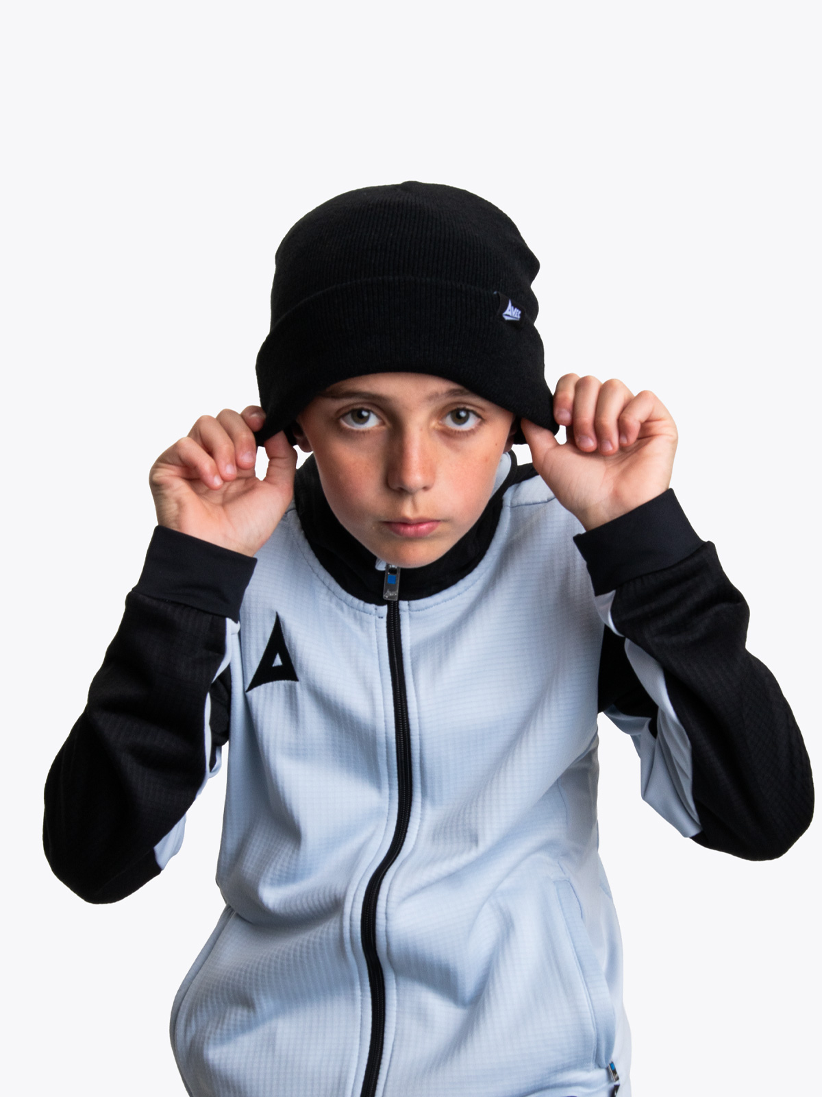 a young boy wearing a black beanie hat with a grey and black track hoodie